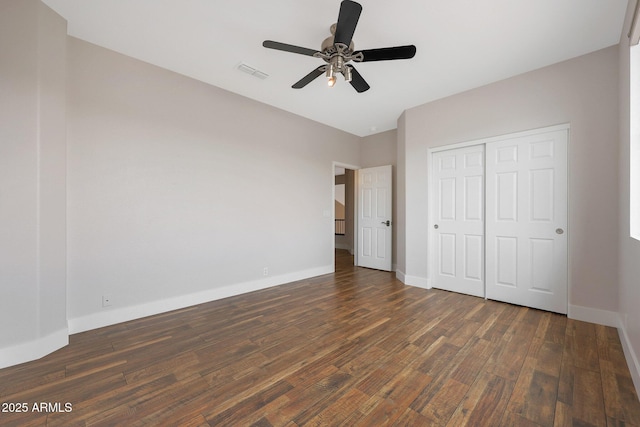 unfurnished bedroom featuring a closet, dark hardwood / wood-style floors, and ceiling fan