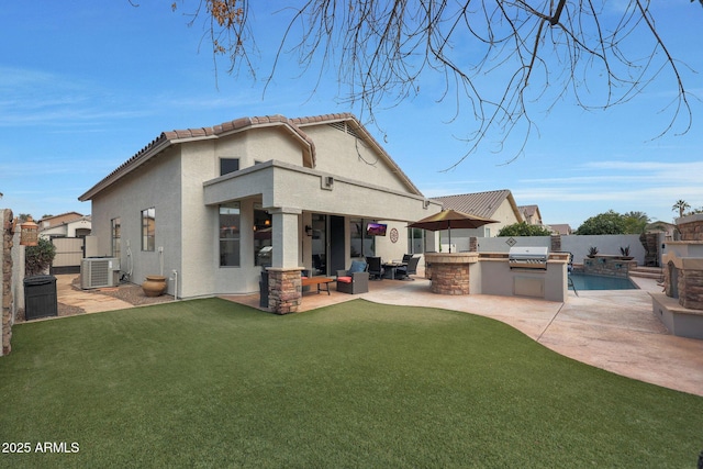 back of property featuring cooling unit, a yard, a patio, and exterior kitchen