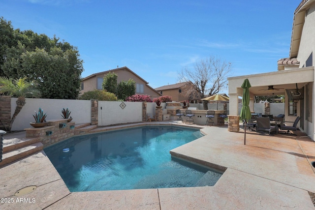 view of pool featuring ceiling fan, exterior kitchen, and a patio area