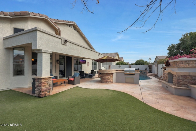 view of yard with a patio, an outdoor kitchen, and an outdoor stone fireplace