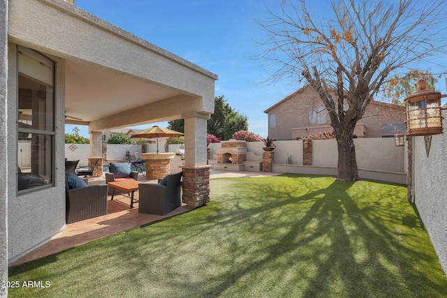 view of yard featuring an outdoor kitchen, an outdoor living space with a fireplace, and a patio area