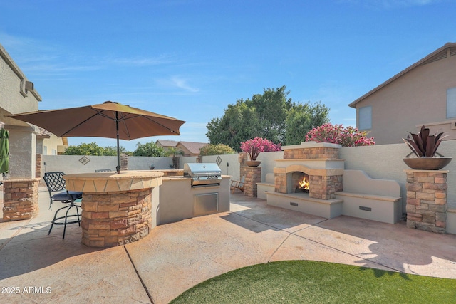 view of patio / terrace with area for grilling, a grill, an outdoor bar, and an outdoor stone fireplace