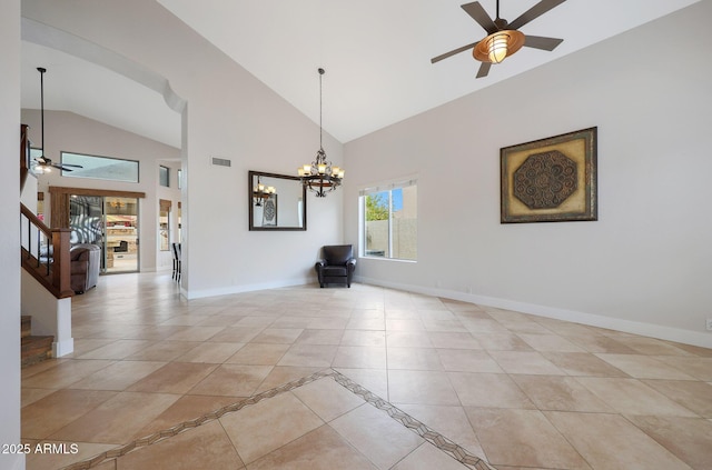 tiled empty room featuring high vaulted ceiling and ceiling fan with notable chandelier