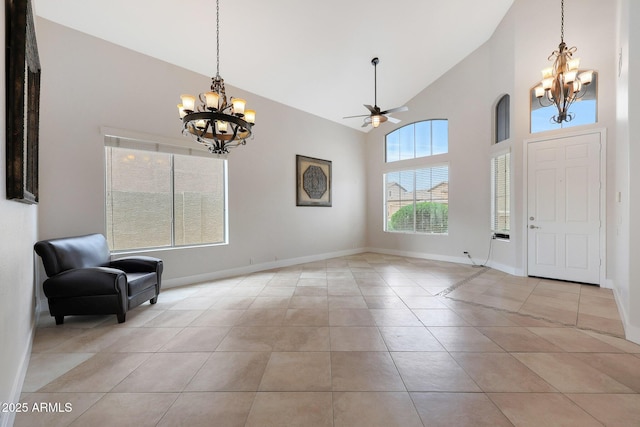 tiled foyer featuring ceiling fan with notable chandelier and high vaulted ceiling