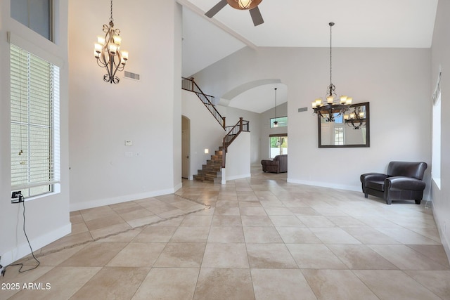 tiled foyer entrance featuring ceiling fan with notable chandelier, high vaulted ceiling, and beamed ceiling