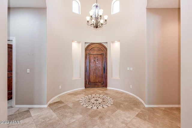 foyer entrance with a towering ceiling and a notable chandelier