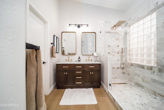 bathroom with vanity and a tile shower