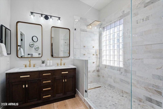 bathroom with hardwood / wood-style flooring, tiled shower, vanity, and a wealth of natural light