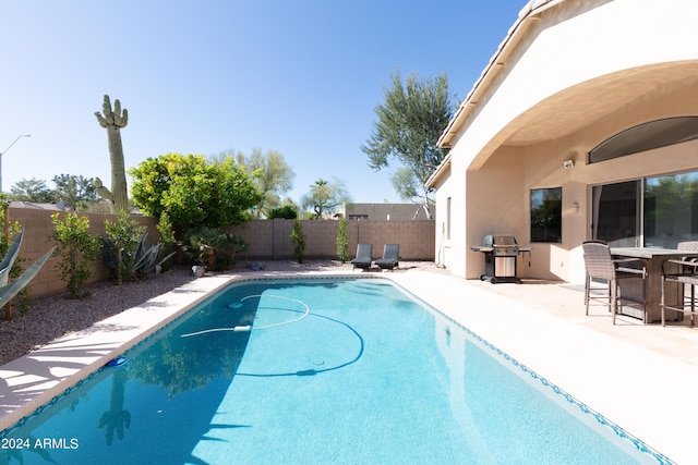 view of swimming pool with a grill and a patio area