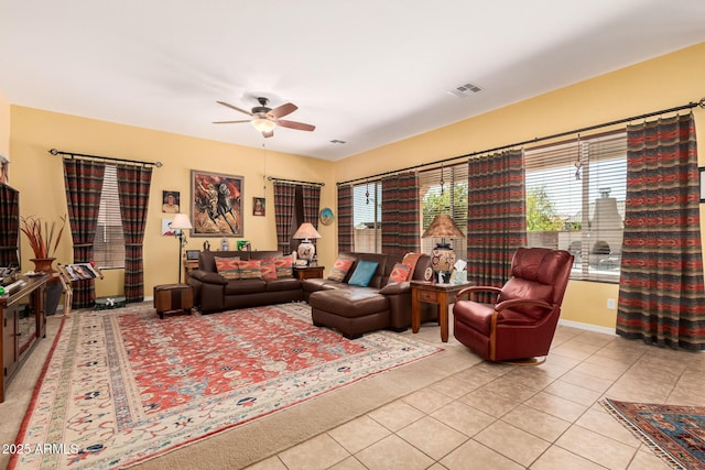 living room with light tile patterned floors, visible vents, and a ceiling fan