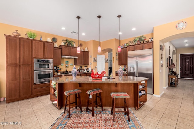 kitchen with stainless steel appliances, visible vents, arched walkways, and open shelves