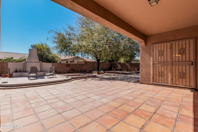 view of patio / terrace with a fenced backyard and a fireplace