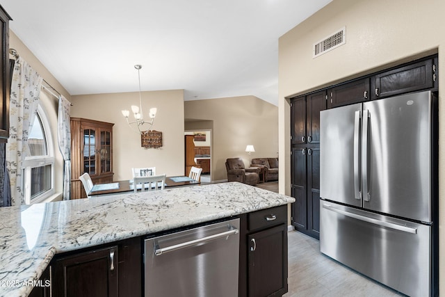 1770 W Derringer Way, Chandler, AZ 85286 - kitchen with visible vents, lofted ceiling, a peninsula, a notable chandelier, and stainless steel appliances
