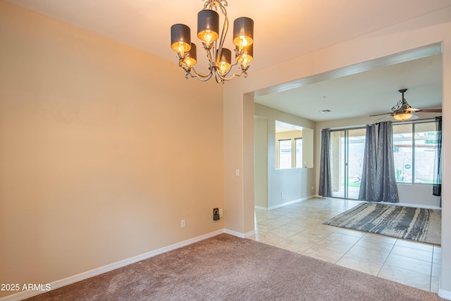 carpeted empty room featuring tile patterned floors, ceiling fan with notable chandelier, and baseboards