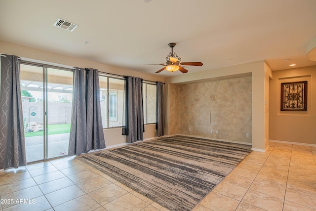 spare room with recessed lighting, a ceiling fan, visible vents, and baseboards