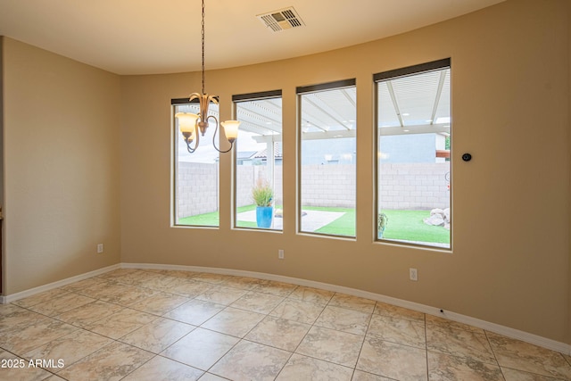 empty room featuring visible vents, baseboards, and an inviting chandelier