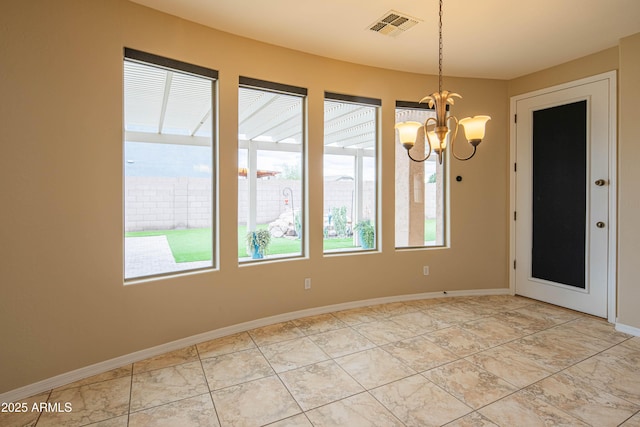 unfurnished room with an inviting chandelier, baseboards, and visible vents