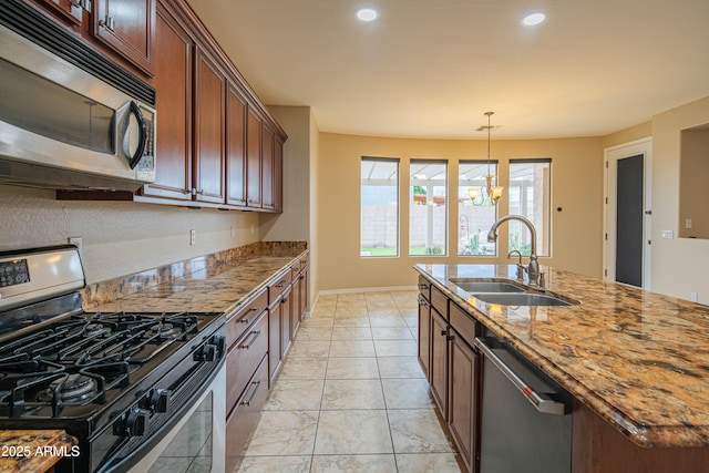 kitchen with pendant lighting, light stone counters, a notable chandelier, stainless steel appliances, and a sink