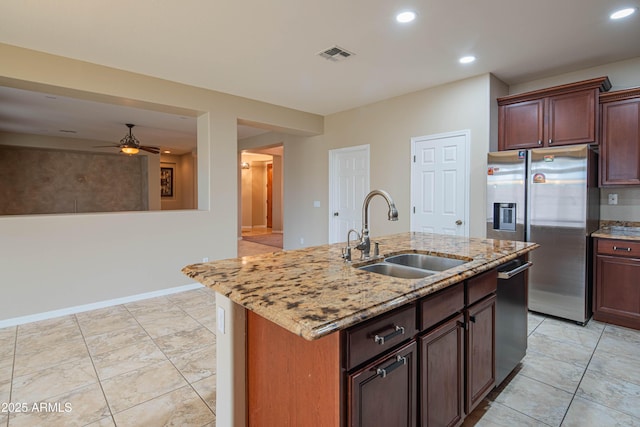 kitchen featuring light stone countertops, visible vents, ceiling fan, a sink, and appliances with stainless steel finishes