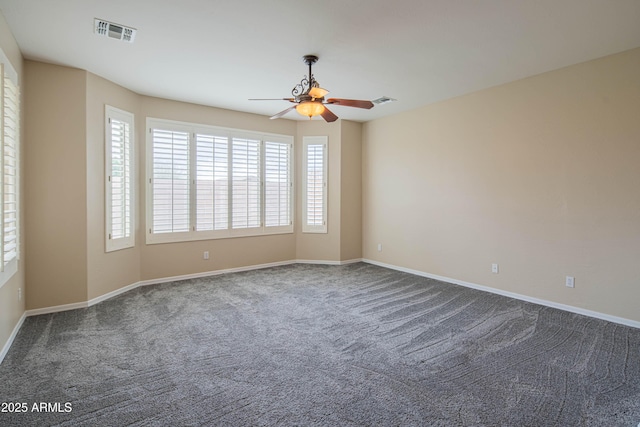 spare room with visible vents, dark carpet, baseboards, and ceiling fan