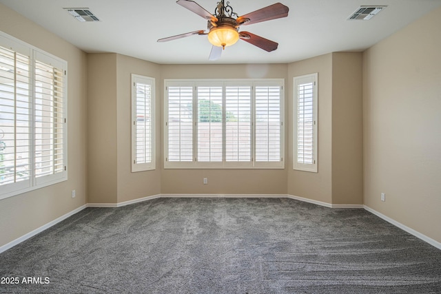 carpeted empty room with a wealth of natural light, visible vents, and a ceiling fan