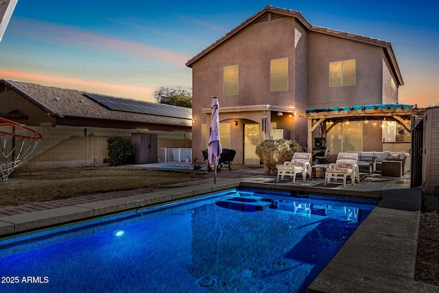 pool at dusk featuring outdoor lounge area, a patio area, and a pergola