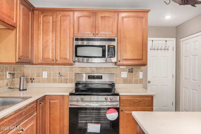 kitchen featuring tasteful backsplash, appliances with stainless steel finishes, and sink