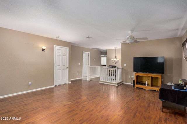 living room with dark hardwood / wood-style flooring, ceiling fan with notable chandelier, and a textured ceiling