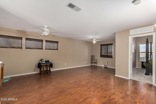 unfurnished living room with dark wood-type flooring and ceiling fan