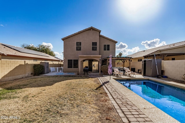 rear view of property featuring a fenced in pool, a patio, and a pergola