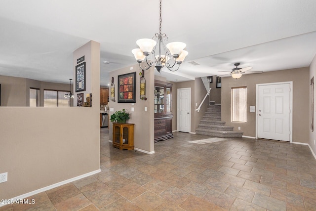 foyer entrance with a healthy amount of sunlight and ceiling fan with notable chandelier