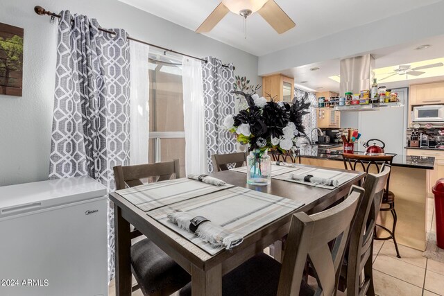 dining area with sink, ceiling fan, and light tile patterned flooring