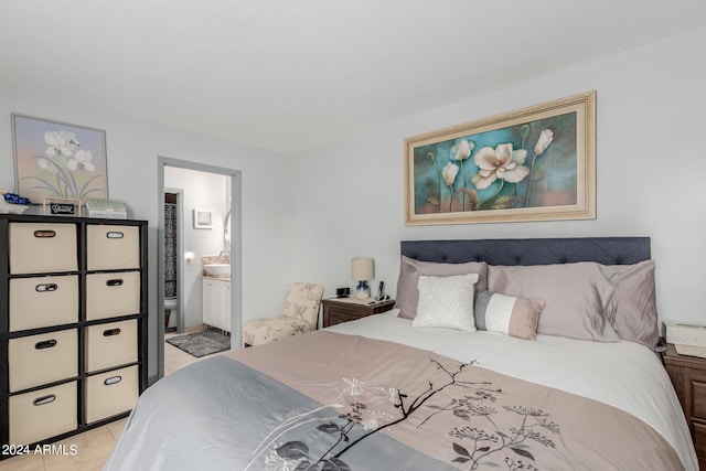 bedroom with light tile patterned floors, sink, and ensuite bath