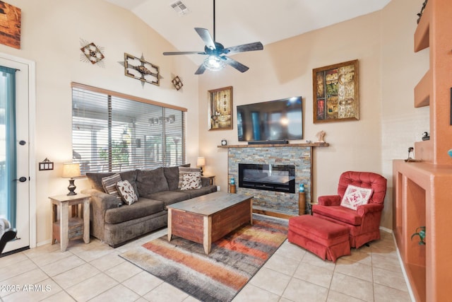 living room featuring ceiling fan, light tile patterned flooring, a fireplace, and vaulted ceiling