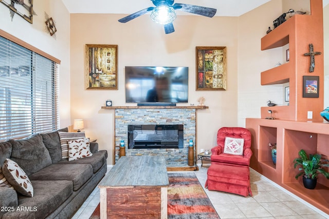 living room with a fireplace, light tile patterned floors, and ceiling fan