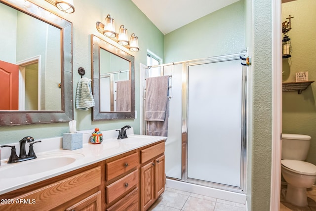 bathroom featuring tile patterned flooring, vanity, toilet, and walk in shower