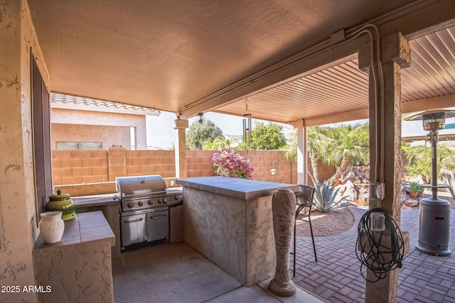 view of patio / terrace featuring a bar and exterior kitchen