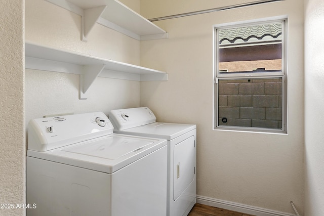 laundry room with washing machine and clothes dryer, laundry area, baseboards, and wood finished floors