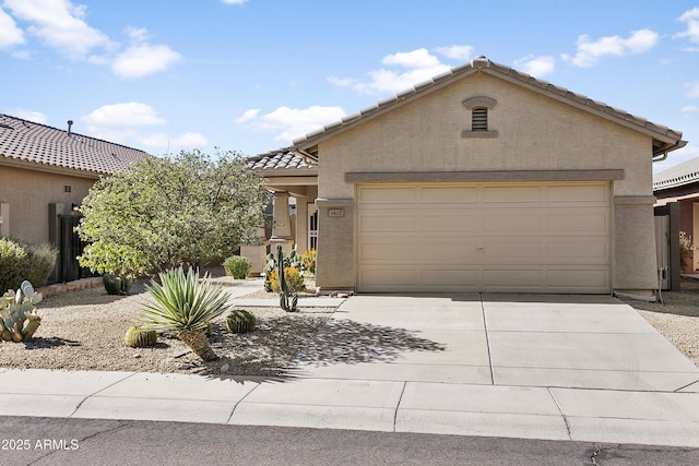 view of front of home featuring stucco siding, concrete driveway, a tile roof, and an attached garage