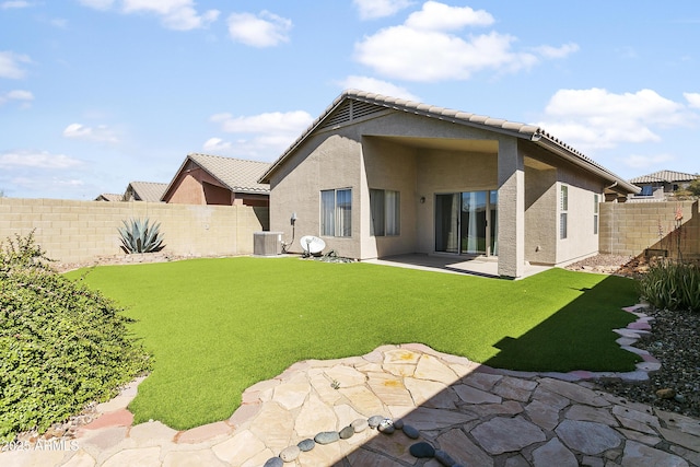 rear view of property with a patio, a fenced backyard, central AC, and stucco siding