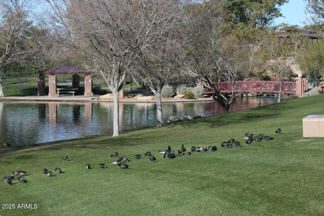 view of home's community with a gazebo, a yard, and a water view