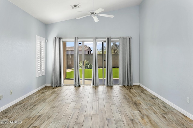 unfurnished room featuring visible vents, lofted ceiling, baseboards, and wood finished floors