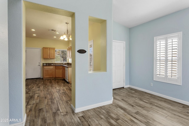 interior space featuring visible vents, a sink, dark countertops, dark wood finished floors, and dishwasher