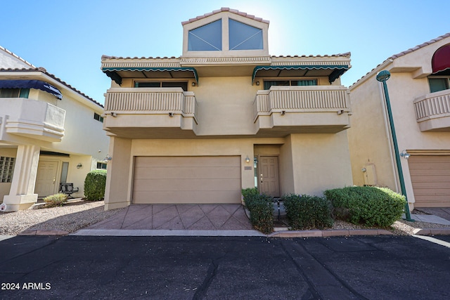 townhome / multi-family property featuring a balcony and a garage