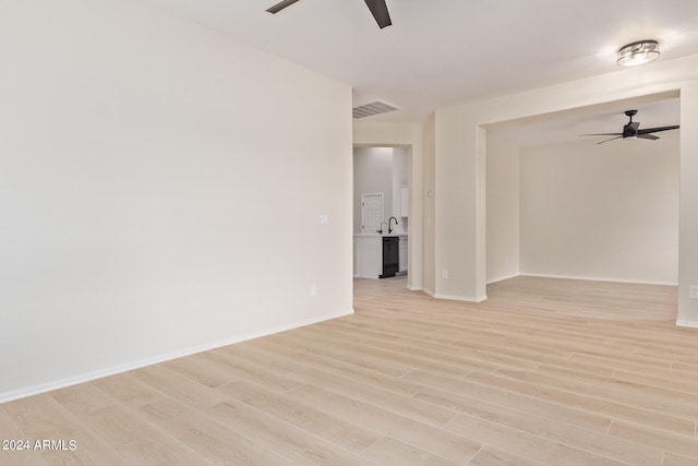 empty room with light wood-type flooring and ceiling fan