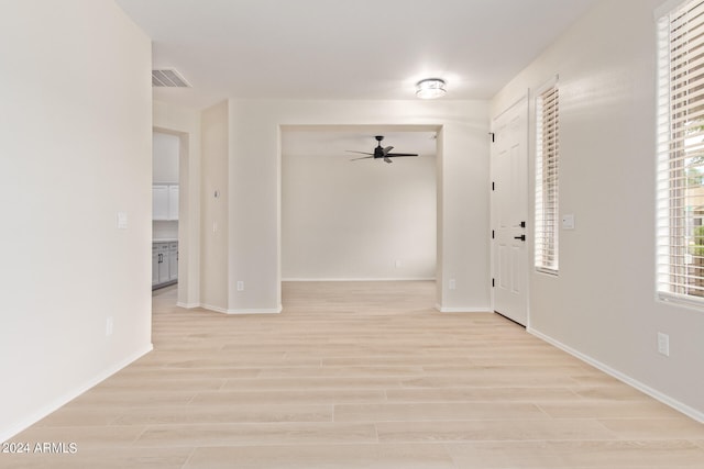 empty room with light wood-type flooring and ceiling fan