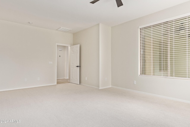 spare room featuring ceiling fan and light colored carpet