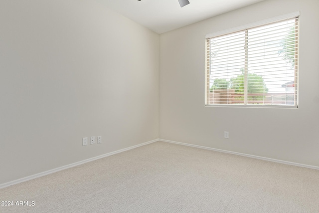 empty room featuring light colored carpet and ceiling fan