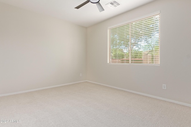 carpeted spare room featuring ceiling fan