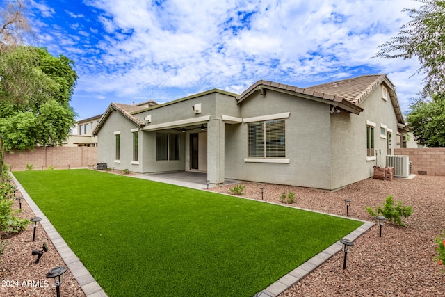 rear view of house with cooling unit, a yard, and a patio area